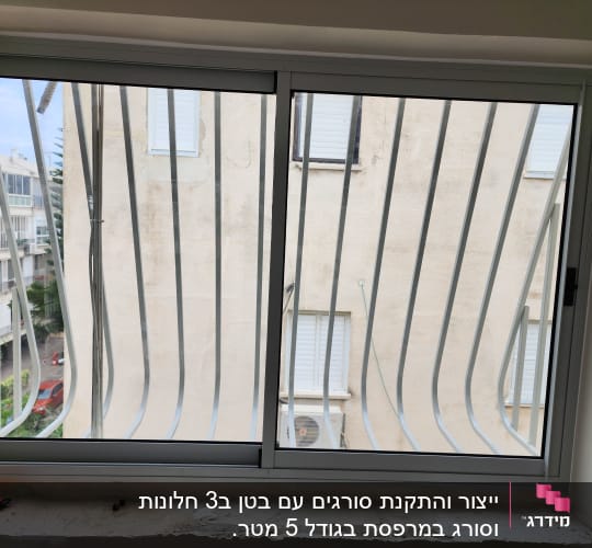 חלון עם מסגרת מתכת וסורגים חיצוניים